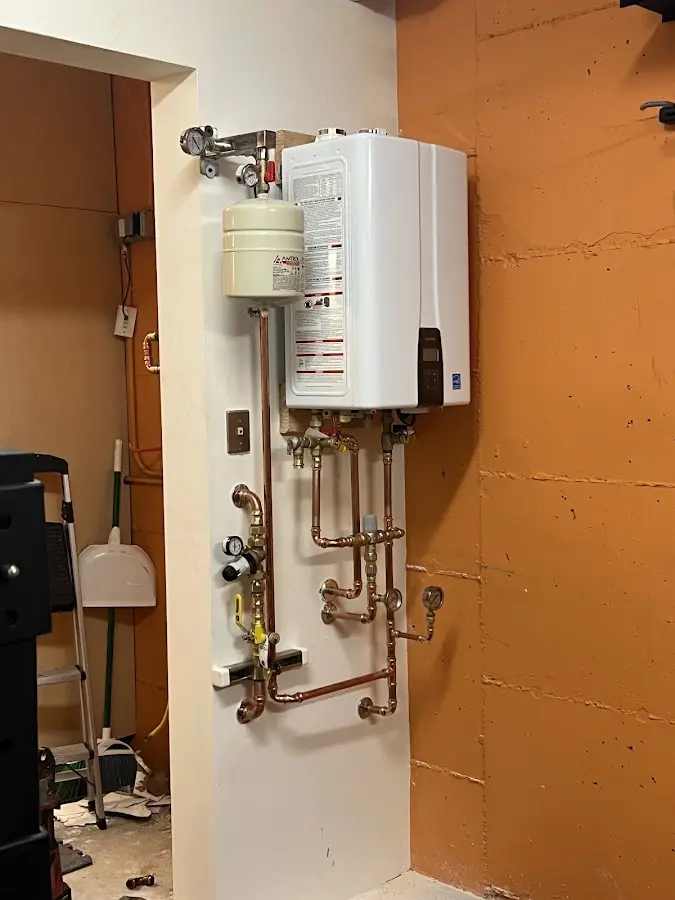 Plumbing technician inspecting water heater connections in Spring Garden